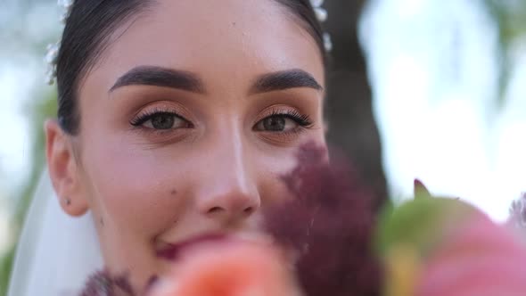 Beautiful Bride Holding a Bouquet Close Up and Looking Into the Frame alt