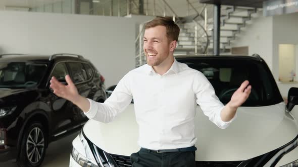 The Man Shows Emotions of Happiness Near His New Car alt