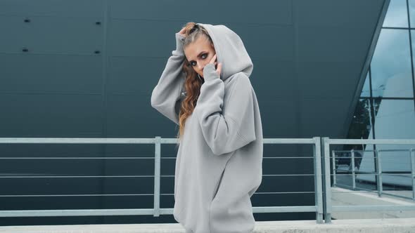 Fashionable Funky Dancer Woman in Sportswear is Performing Outdoor Street Dancing Motion alt