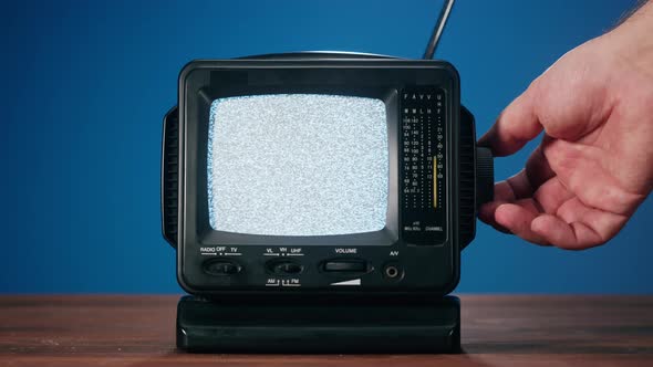 Small Old Television with Grey Interference Screen on Blue Background alt
