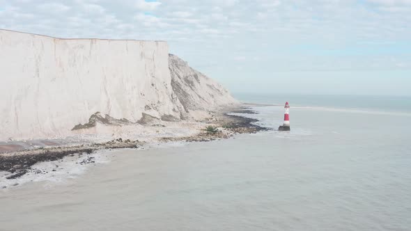Circling drone shot around red white beachy head light house White cliffs UK alt