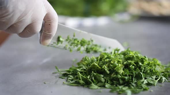 Chef cuts with knife parsley,dill and cilantro, close up