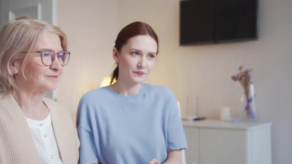 A Pensioner and a Young Woman Show Diagrams to the Camera and Make a Business Presentation alt