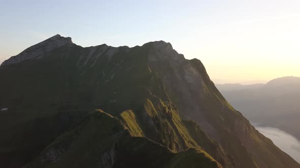 Aerial Rotation Shot Of A Mountain Ridge In Switzerland During Sunrise alt