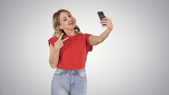 Joyous woman 30s wearing red t-shirt taking selfie photo alt
