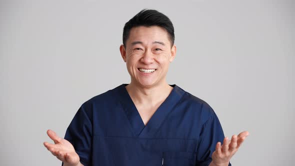 Pretty smiling Asian doctor talking something at the camera alt