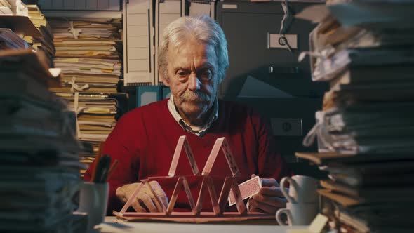 Lazy office clerk building a card castle on the desk