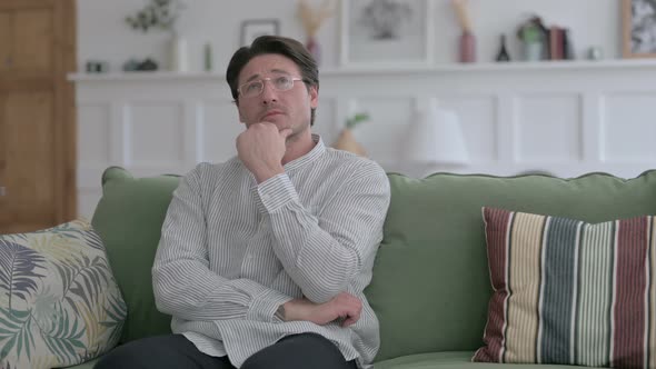 Man Thinking while Sitting on Sofa alt