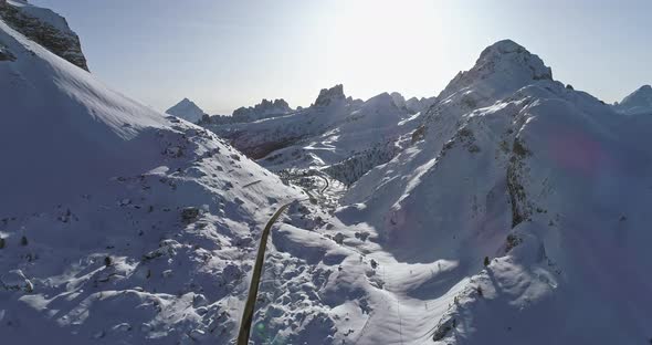 Forward Aerial Along Road Above Snowy Valley at Valparola Pass