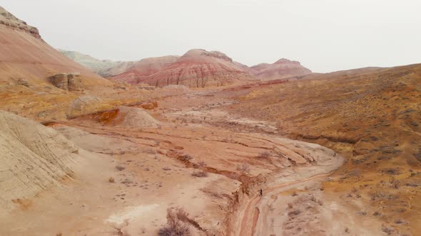 Drone Shot of Bicyclist Ride in Canyon Desert Mountains in Kazakhstan alt