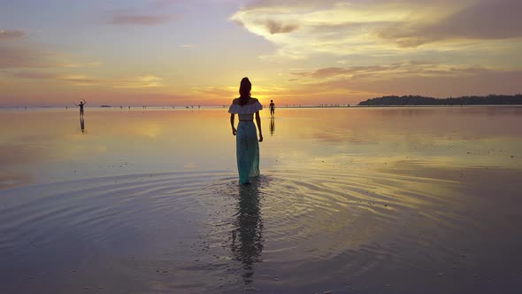 Young Woman Silhouette Walking on the Sea at Beautiful Sunset Thailand