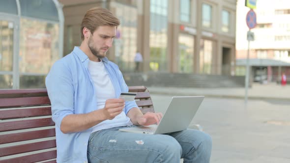 Excited Man Shopping Online with Laptop Outdoor alt