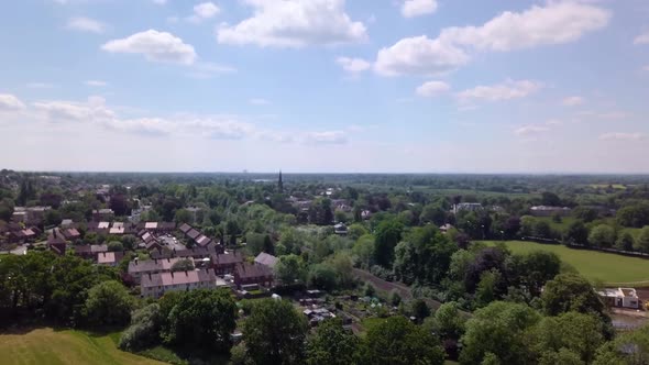 Drone flying over urban landscape in Alderley Edge, Cheshire, UK  - showing suburban greenbelt and a alt