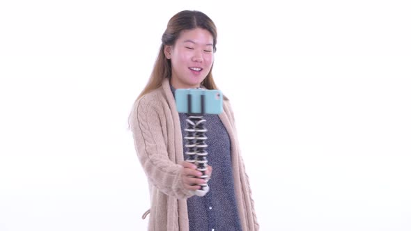 Happy Young Asian Woman Vlogging with Phone in Winter alt