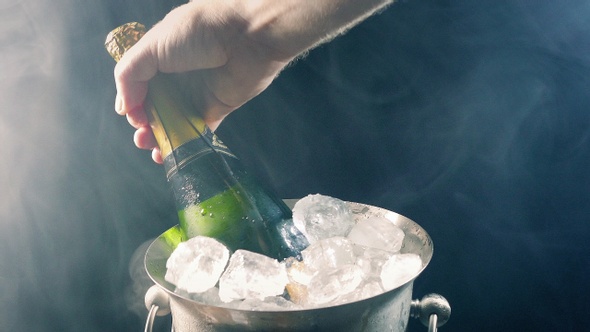Champagne Bottle Taken From Ice Bucket With Cold Vapor alt