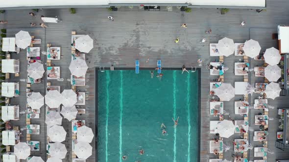 Aerial top view on swimming pool full of people having fun.  alt