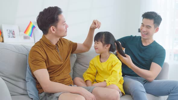 Asian attractive LGBTQ gay family comb hair and spend time with girl kid daughter together at home. alt