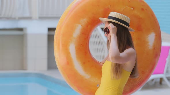 Carefree Beautiful Stylish Caucasian Blonde Woman with Long Hair in Hat and Sunglasses By Pool in alt
