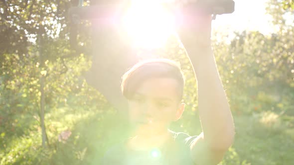 A Teenage Boy Holds the Edge of a Swing and Looks at the Camera