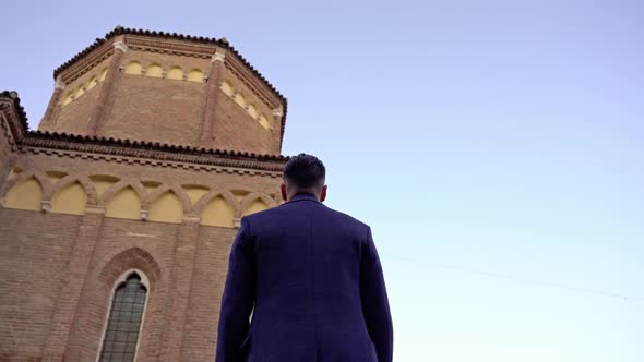 Motion Around Man in Elegant Coat on Ancient City Square alt