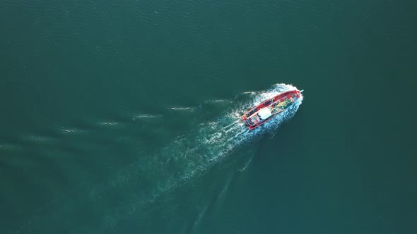 Drone flying over a fishing boat that is sailing on the sea alt