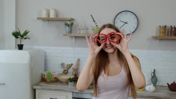 Joyful Young Girl Vegan Dancing Holding Fresh Red Slice of Bell Pepper on Eyes. Healthy Nutrition alt