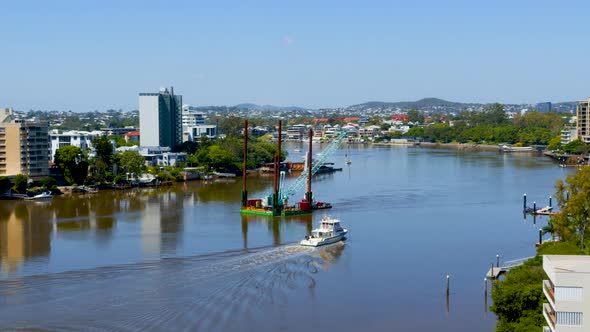 A floating crane barge is manoeuvred up the river to help repair the damage of the ferry terminals a alt