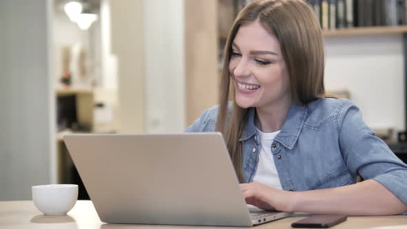 Creative Woman Celebrating Success While Working on Laptop alt