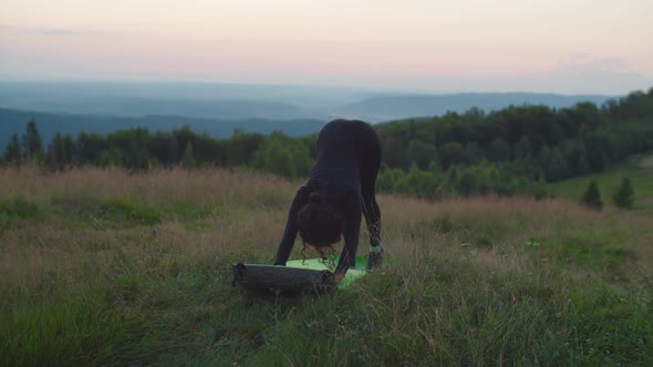 Slim Flexible Sporty Fit African American Female Doing Downward Facing Dog Pose in Mountains at alt