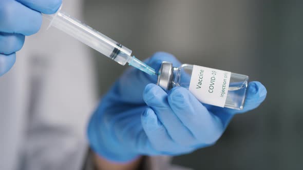 Unrecognizable Doctor Filling Syringe with Vaccine alt