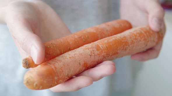 Woman Showing Carrots From Private Store or Supermarket in the Hands Closeup