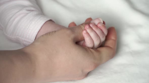Newborn Childs Palm of Newborn Baby Girl in Mothers Hands