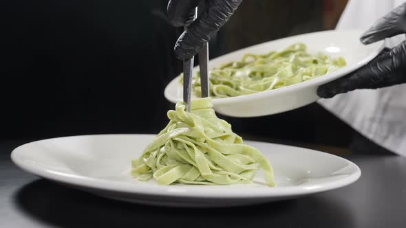 Cooking Pasta in Italian Restaurant. Chef Serving Cooked Pasta on Plate. Slow Motion. Vapour or alt