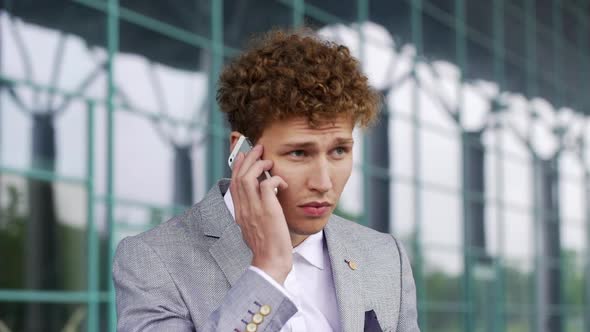 Close Up Slow Motion of Handsome Businessman Making Phone Call Waiting for Taxi Outside Office
