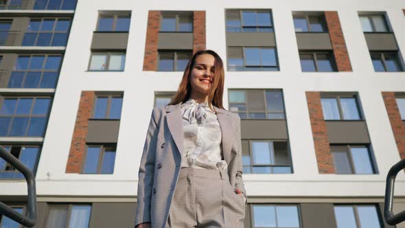 Young Woman in a Business Suit Descends the Stairs on the Background of the Building Slow Motion alt
