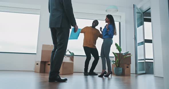 Cheerful multiethnic couple dancing in the livingroom alt