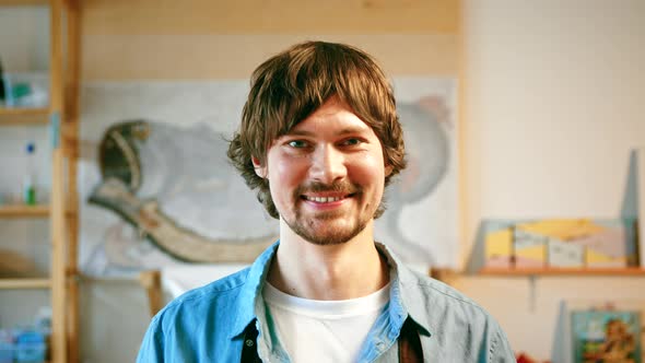 Smiling man in an apron looking at camera in studio alt