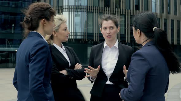 Confident Female Leader Negotiating with Business Group Explaining Contract Benefits at Informal