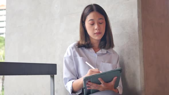 Cute girl drawing with stylus on digital tablet while sitting in drawing program concept. alt