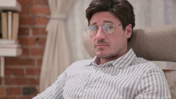 Portrait of Middle Aged Man Feeling Sad towards Camera at Home alt
