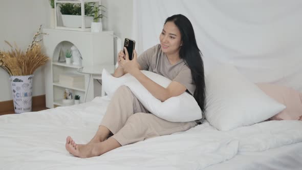 Woman using mobile phone to video call with girlfriend to communicate at a distance.
