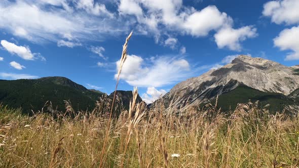 Fast clouds movement on sky in scenic mountains valley view. Landscape panorama with weather. alt