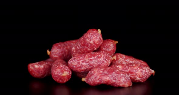 Pile Whole Sticks of Salami on the Table Slowly Rotates.  alt