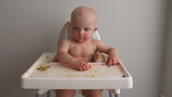 Funny Baby Soiled in Food Making Mess While Eating Tomatos. alt
