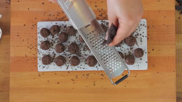 Woman Grating Dark Chocolate on Cake with Hand Grater