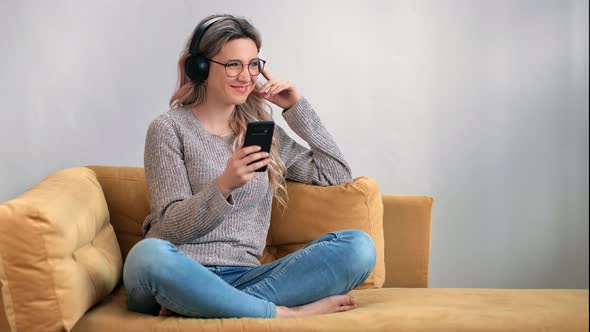 Joyful Woman Laughing Listening Music in Headphones Use Smartphone alt