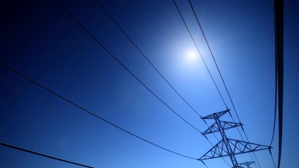 Endless electric powerlines and pylons loopable animation on a navy blue sky. HD alt