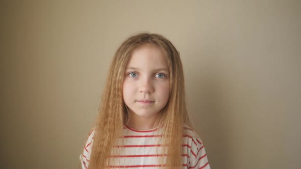 Small Kid Long Blonde Hair Looking Into Camera Shocked Expression Indoor alt