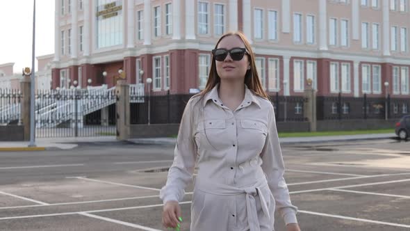 Beautiful Young Girl with Glasses Walks Through the City and Looks Around