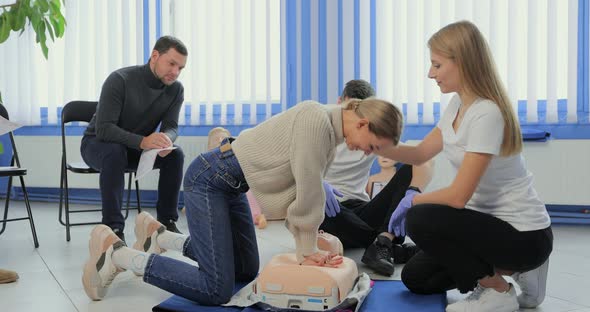 Woman Demonstrating CPR on Mannequin in First Aid Class alt